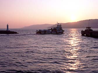 夕暮れのダーダネルス海峡、出航する船のシルエットともうすぐ沈む夕陽