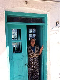 真っ白な壁に青緑のドア。ささやかな土産物を売るおばちゃんが手招きしている。